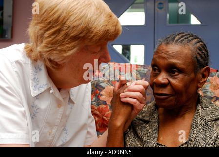 Membro del personale di assistenza interagendo con donna anziana presso la casa di cura per le persone affette da demenza, Londra, Regno Unito. Foto Stock