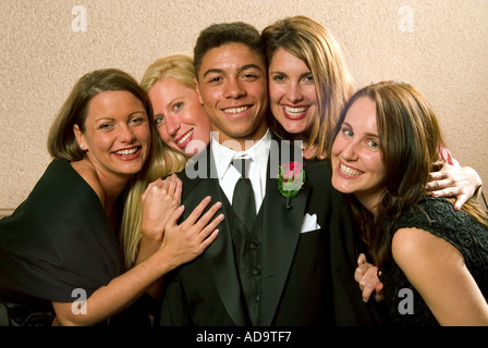 Un felice giovani groomsman è circondato da incantevoli Ladies presso la reception per un formale le nozze cattoliche in Costa Mesa CA Foto Stock