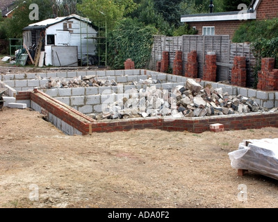Terreno edificabile e una nuova casa unifamiliare Fondamenti completati & mucchi di hardcore per essere livellate per pavimento in calcestruzzo muratura in mattoni & blockwork al livello del DPC Foto Stock