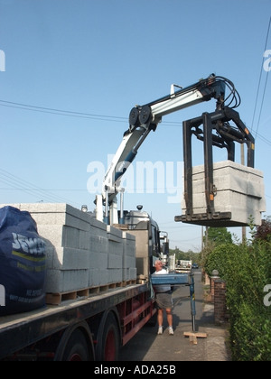 Meccanica offload della gru del camion carico di blocchi in calcestruzzo sollevato dal pallet su House Building site a mezzo camion gru montata Essex England Regno Unito Foto Stock