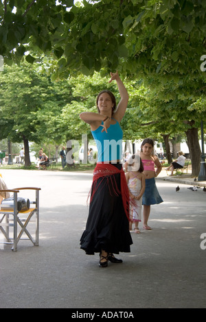 Giovane donna greca danze come i bambini a guardare, Spianada, Corfu, Corfù, Grecia, Foto Stock