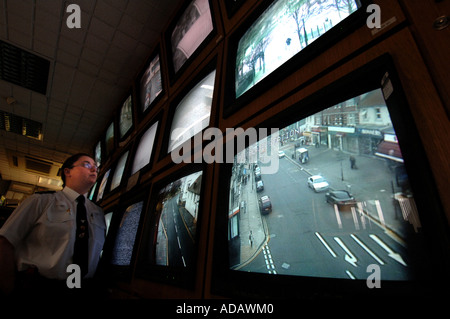 Un operatore TVCC a Brighton stazione di polizia controlla una banca di schermi da telecamere CCTV monitoring per le strade della città Foto Stock