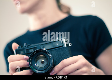 Abstract del giovane femmina caucasica utilizzando un telemetro classica fotocamera Foto Stock