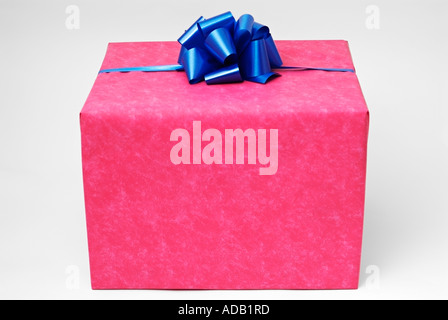 Gift Wrapped presente con carta rossa e un nastro di colore blu Foto Stock