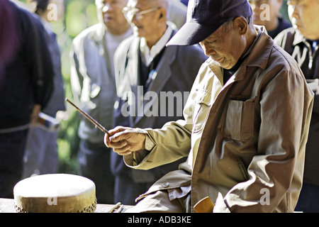 Cina Pechino cinese anziano gentiluomo gioca il tamburo Cinese presso il Tempio del Paradiso Park Foto Stock
