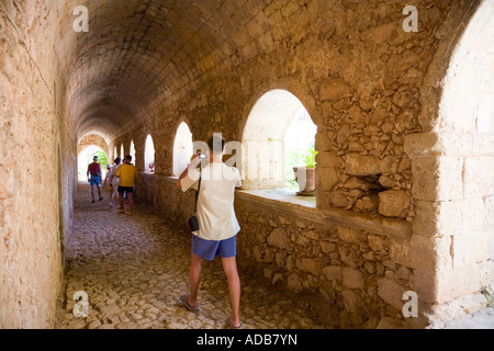 I turisti a piedi attraverso un corridoio nel monastero di Arkadi / Creta / Grecia Foto Stock