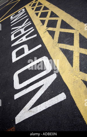 White parcheggio non verniciato su asfalto lungo con giallo croce boxed botole di evacuazione nel parco auto Foto Stock