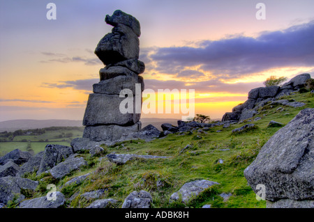 Bowermans Naso di roccia di granito formazione vicino Hayne giù sul Dartmoor con il sorgere del sole direttamente dietro Foto Stock