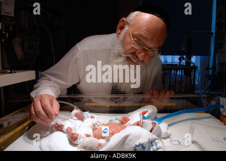 Un medico Haredi che controlla il neonato prematuro in un incubatore presso l'unità di terapia intensiva neonatale del Centro medico Share Zedek di Gerusalemme ovest Israele Foto Stock