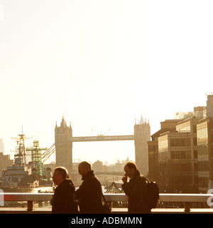 Andare al lavoro la mattina presto a chi lavora in ufficio camminando su London Bridge Tower bridge sull orizzonte Foto Stock