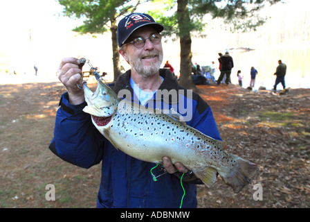 Un uomo detiene una grande trota Marrone dopo la cattura in apertura di giornata di pesca a Wallingford Connecticut Foto Stock