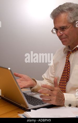 Un vecchio uomo d affari. soddisfatti alcuni lavori che egli ha appena fatto sul suo computer Foto Stock