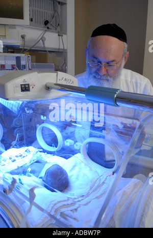 Un medico Haredi che controlla il neonato prematuro in un incubatore presso l'unità di terapia intensiva neonatale del Centro medico Share Zedek di Gerusalemme ovest Israele Foto Stock