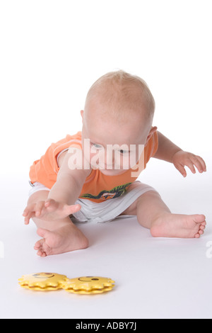 Little Boy raggiungendo per un giocattolo Foto Stock