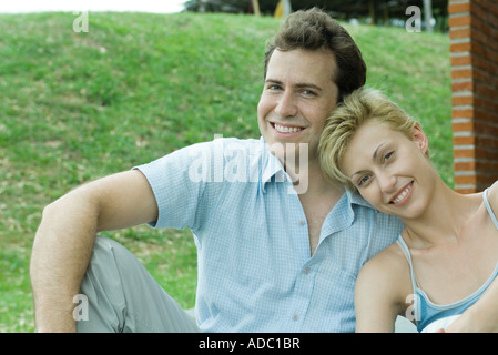 Matura in seduta backyard sorridente in telecamera, close-up Foto Stock