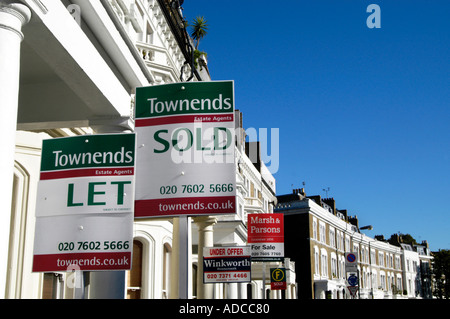 In affitto e in vendita segni di proprietà in strada residenziale, London, England, Regno Unito Foto Stock