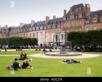 Persone rilassante nella Place des Vosges parco le marais parigi francia Foto Stock