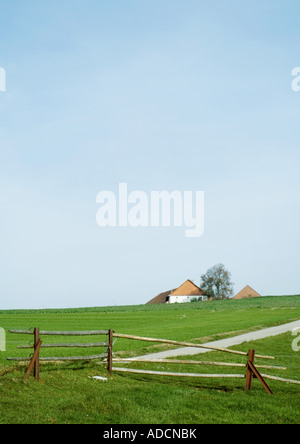 Paesaggio con agriturismo e recinzione di legno Foto Stock