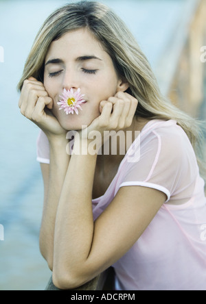 Donna con fiore in bocca, gli occhi chiusi Foto Stock