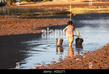 Ragazza raccolta di acqua dalla Nam Ou River Foto Stock
