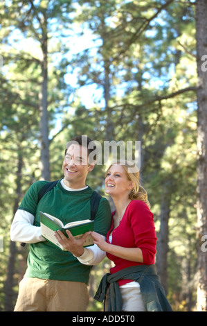 Coppia caucasica consultare la guida durante le escursioni attraverso la pineta sul sentiero natura Foto Stock