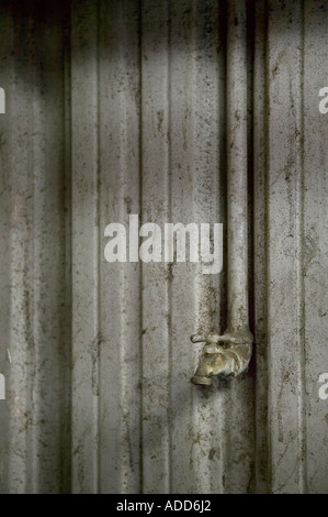 Rubinetto acqua e tubazione collegata al lato della parete grungy Foto Stock