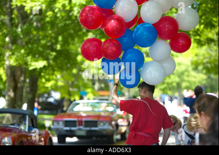 Grande grappolo di rosso, bianco e blu palloncini detenute dal venditore al 4 di luglio Parade, Brooklyn, Maine Foto Stock