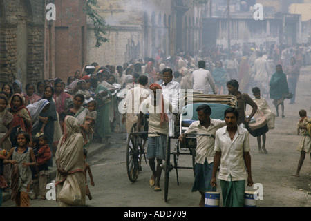 Rickshaws pass poveri in coda per il cibo la mattina presto a Madre Teresa s missione Calcutta India Foto Stock