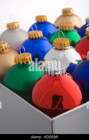 Closeup ritratto in studio di colorato albero di Natale ornamenti della lampadina nel riquadro grigio Foto Stock