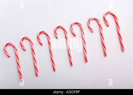 Primo piano di sette striped Natale candy canes angolato sul fondo bianco ritratto in studio Foto Stock