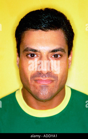 Testa e spalle Ritratto di uomo che indossa una camicia verde nella parte anteriore della parete gialla Foto Stock