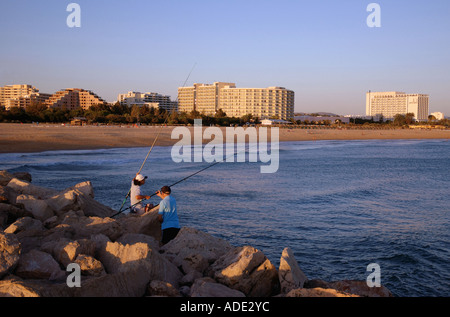 Vista sulla tranquilla spiaggia di tramonto & uomini pesca nel molo di Vilamoura Algarve Portogallo Iberia Europa Foto Stock