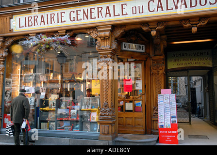 Anziani uomo francese cercando nella libreria tradizionale, "Librairie Generale du Calvados" Rue St Pierre, Caen.la Normandia, Francia. Dec Foto Stock