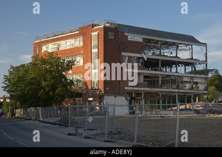 Vecchia fabbrica uffici demolizione sito (parzialmente demolito struttura circondata da protezione di sicurezza recinzioni) - Guiseley, West Yorkshire, Inghilterra UK. Foto Stock