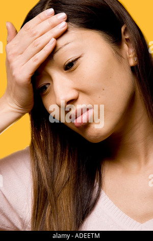 Giovane donna con un mal di testa, eventualmente un'emicrania o semplicemente di una giornata stressante. Foto Stock