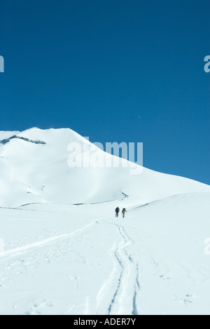 Gli sciatori si muove in salita a distanza Foto Stock