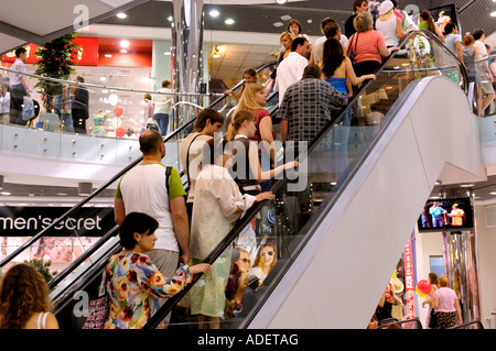 Le persone sulla scala mobile in un centro commerciale per lo shopping Foto Stock