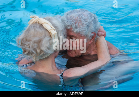 Coppia di anziani abbracciando in piscina Foto Stock