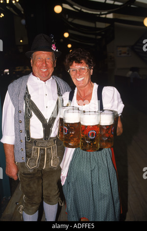 Cameriera con bicchieri di birra bavarese e uomo al Oktoberfest a Monaco di Baviera Foto Stock