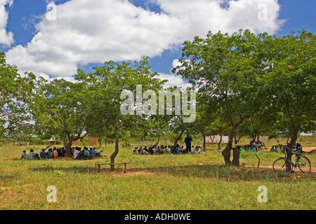 Le famiglie di attendere in ombra per la consegna di un aiuto alimentare a scuola Hinjali Monze Zambia Foto Stock