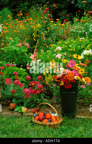 Fiori in vaso di metallo lungo con frutta e verdure raccolte da giardino fiorito, Missouri USA Foto Stock