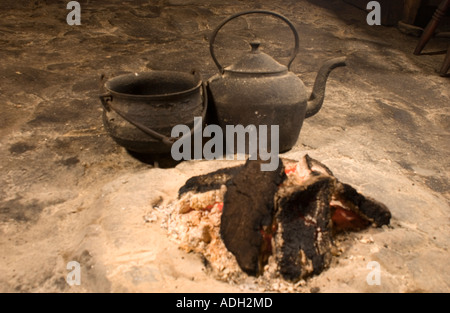 Il fuoco al centro del pavimento di pietra su un tampone di cuocere argilla, blackhouse, Arnol, Lewis, Ebridi Esterne, Scotland, Regno Unito Foto Stock