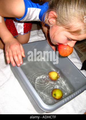 Giovane ragazza il ducking per le mele di Halloween Foto Stock