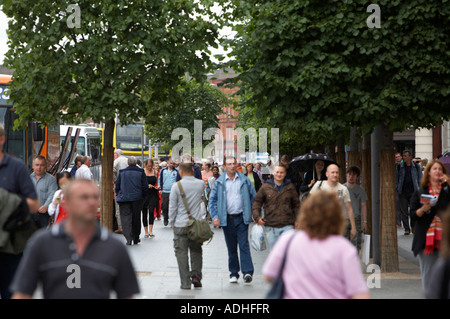 La folla di gente che cammina verso il basso oconnell street tra gli alberi su nuvoloso giorno di estate Foto Stock