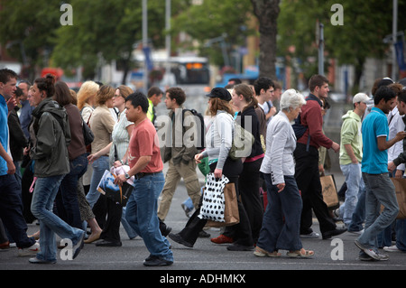 Le persone che attraversano un incrocio occupato su oconnell street dublin durante le ore di punta Foto Stock