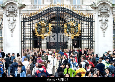 La folla di turisti si sono riuniti di fronte a Buckingham palace London Inghilterra England Foto Stock