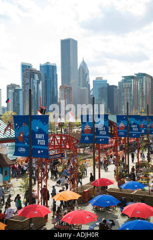 CHICAGO Illinois banner su pali della luce a Navy Pier ombrelloni colorati gente camminare edifici della città in distanza Foto Stock