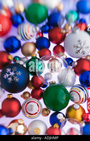 Varietà di coloratissimi albero di Natale ornamenti a sfera impilate su sfondo bianco ritratto in studio Foto Stock