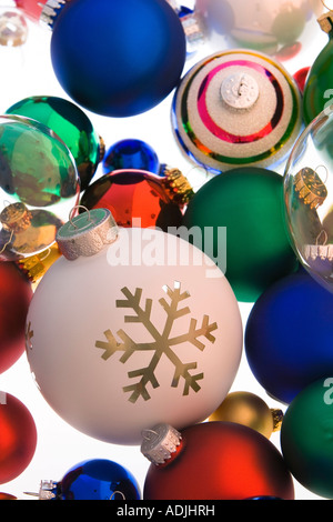 Varietà di coloratissimi albero di Natale ornamenti a sfera impilate su sfondo bianco ritratto in studio Foto Stock