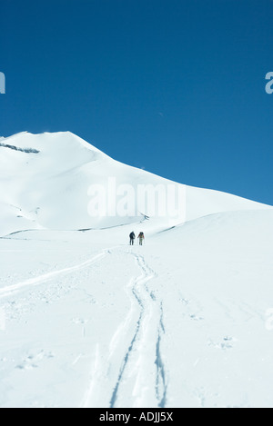 Gli sciatori in direzione di montagna, vista posteriore Foto Stock